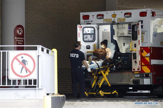 A medical worker wheels a patient from an ambulance to George Washington University Hospital in Washington D.C., the United States, on April 27, 2020. (Photo by Ting Shen/Xinhua)